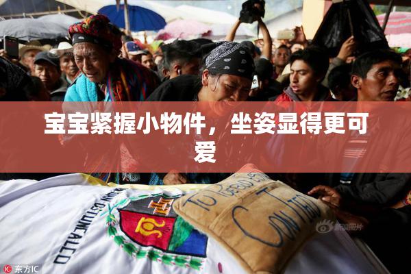 宝宝紧握小物件，坐姿显得更可爱
